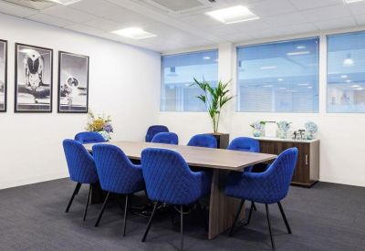 Professional boardroom with blue quilted chairs and large windows.