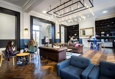 Stylish communal lounge with leather sofas, wood floors, and decorative lighting.