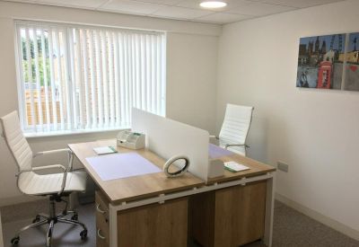 Bright two-person office at Battlefield Road with light wood desks and ergonomic white chairs.