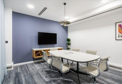 Modern meeting room with a blue accent wall and large wall-mounted screen.