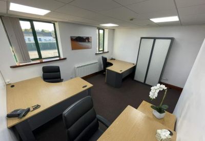 Two-person office suite featuring corner desks and views of surrounding greenery.