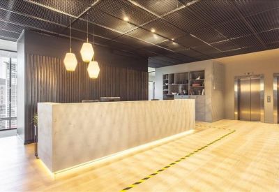 Modern reception area with a minimalist stone desk and designer pendant lighting.