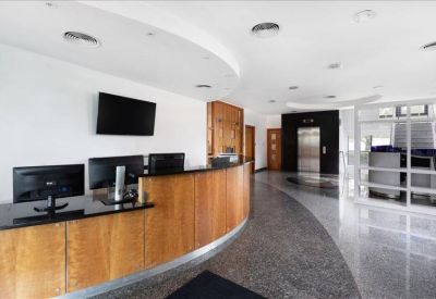 Reception lobby featuring a curved wood desk and polished stone flooring.
