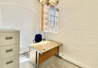 Cozy office with a single desk and a chandelier.