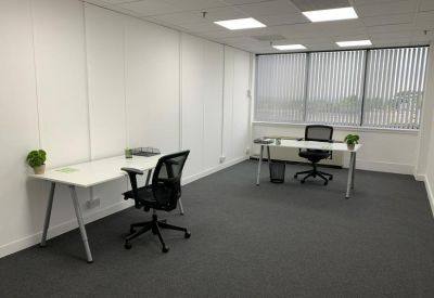 Private two-person office suite with white desks and black ergonomic chairs.