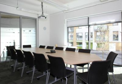 Professional meeting room with a large table, black chairs, and natural light.