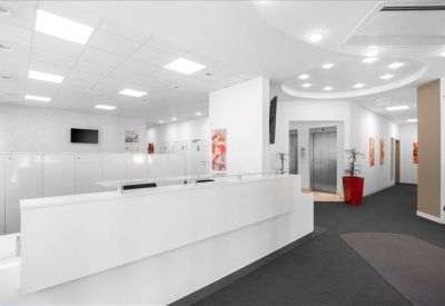 Sleek white reception desk with modern recessed ceiling lighting.