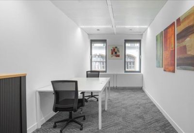 Narrow two-person office suite with abstract wall art.