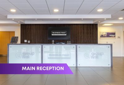 Reception desk with frosted glass panels and a branded wooden feature wall.