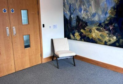 Small seating area featuring a large abstract blue painting and a modern lounge chair.