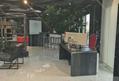 Industrial-style workspace featuring a long dark wood desk and red office chair.