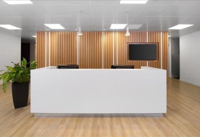 Bright reception area with white desk and vertical wood-slat wall.