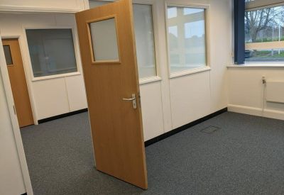 Office with open door and frosted glass partitions.