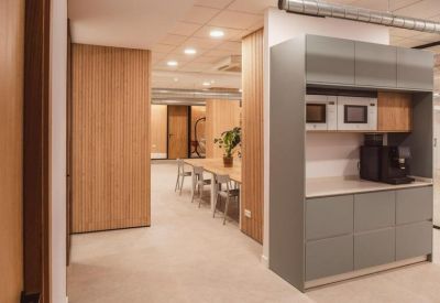 Shared kitchen area with grey cabinetry and integrated coffee machine.