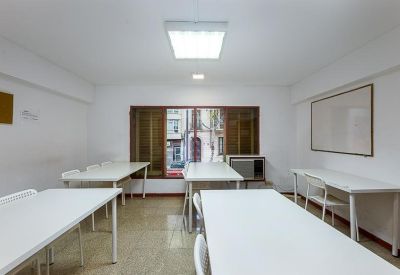 Open-plan workspace with multiple desks and a large window overlooking the street.