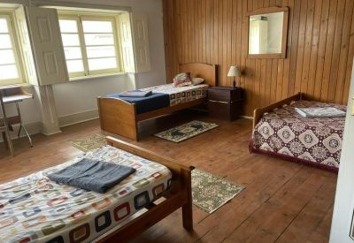 A shared bedroom or breakout space with multiple beds, wooden wall paneling, and large windows.