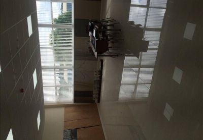 Brightly lit indoor common area with high ceilings, large windows, and reflective flooring.