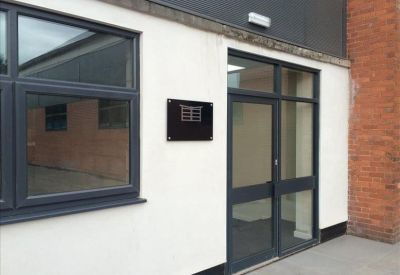 Exterior entrance showing a modern glass door and window set in a white and brick facade.