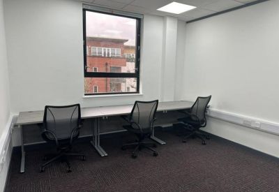 Private office suite with three black mesh chairs and a large window.