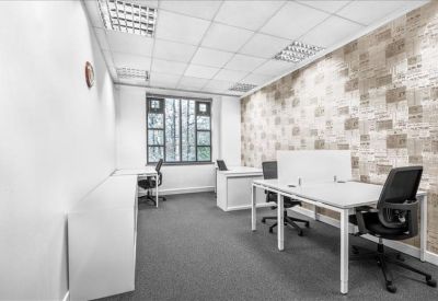 Bright private office suite with white desks and a patterned feature wall.