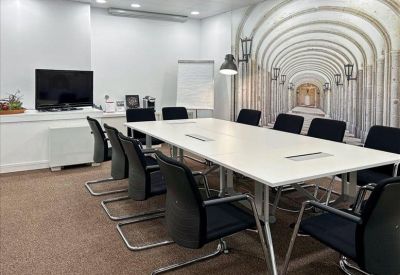 Minimalist white breakout space with high stools and a sleek counter.