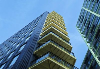 Low angle view looking up at the modern black and yellow facade of the Cheese Lane building.