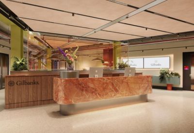 Lobby area featuring a modern marble-patterned reception desk with wood paneling and floral arrangements.