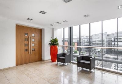 Elevated waiting area with black leather armchairs and a decorative orange planter by the window.