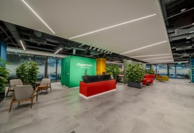 Spacious reception area with a red desk and green branded feature wall.