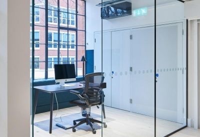 Private glass-enclosed meeting room or executive office with a minimalist desk.