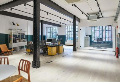 Spacious open-plan workspace at New River Yard with industrial pillars and natural light.