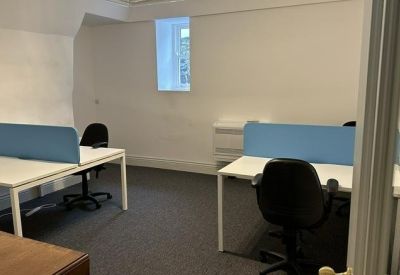 Modern workspace with two workstations, blue dividers, and neutral walls under soft lighting.
