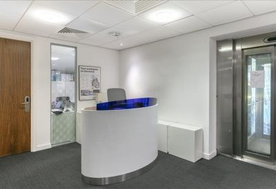 Reception area with a white curved desk and blue glass partition.
