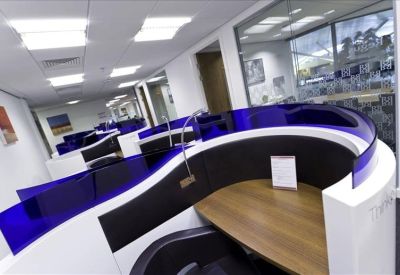 Curved semi-private workstations with blue glass accents in a modern office.