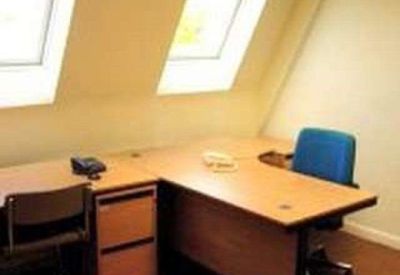 Internal office suite with an L-shaped desk and skylight windows set into a sloped ceiling.