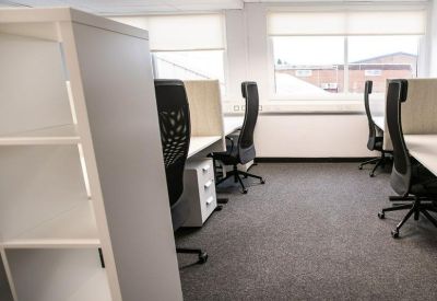 Bright open-plan workspace featuring ergonomic chairs and white desks with storage units.
