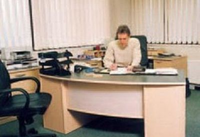 Private office with desk, chair, and large windows.