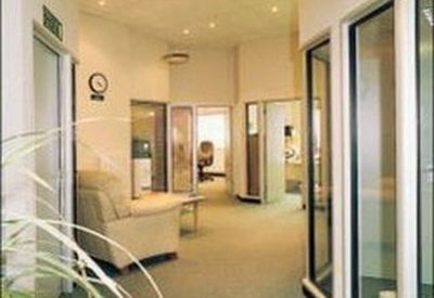 Modern hallway with glass partitions and office doors.