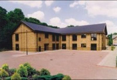 Exterior view of building with a large parking area.