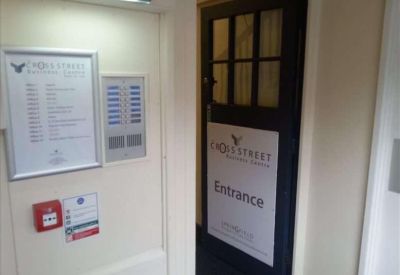 Building entrance featuring a dark wood door with glass panes and a tenant directory board.