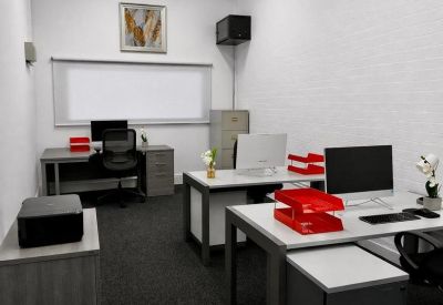 Modern workspace with white desks, red document trays, and a window with blinds.