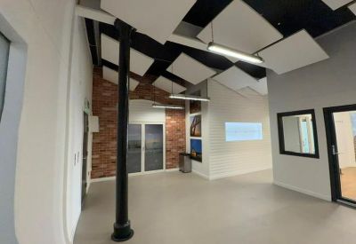 Open communal area featuring acoustic ceiling panels and a decorative brick feature wall.