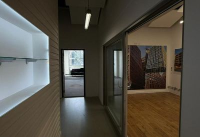 Bright corridor with recessed display shelving leading to a modern office space.