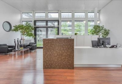 Bright reception area featuring a textured wood-front desk and natural light.