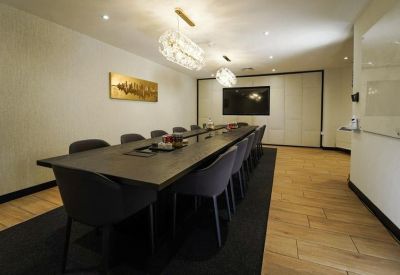 Bright open-plan workspace with rows of white desks and ergonomic black chairs.