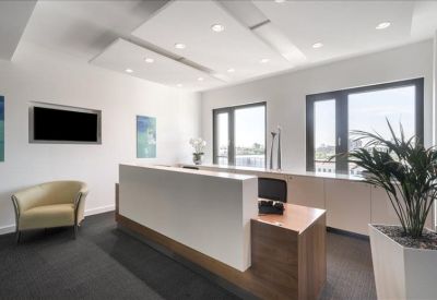 Professional reception desk area with recessed ceiling lighting and a waiting chair.