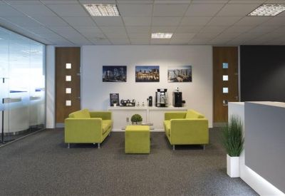 Clean waiting area with lime green sofas and coffee machine station.