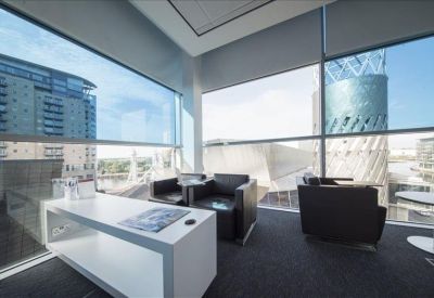 Bright corner office with floor-to-ceiling windows and leather armchairs.