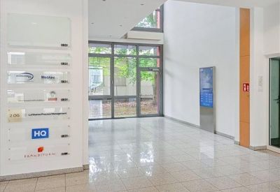 Modern entrance hallway with directory signage and glass windows.