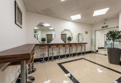 Communal kitchen area with bar stools and mirrors.
